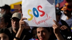 FILE - Venezuelan nationals attend a protest against the official results that declared President Nicolas Maduro the winner of the July presidential election, in Quito, Ecuador, Aug. 17, 2024.