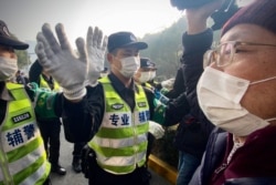 Police attempt to stop journalists from recording footage outside the Shanghai Pudong New District People's Court, where the trial for Chinese citizen journalist Zhang Zhan was held, Dec. 28, 2020.