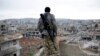 FILE - A Syrian Kurdish sniper looks at the rubble in the Syrian city of Kobani.