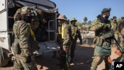 Para kompbatan oposisi Suriah turun dari truk setibanya di Desa Anjara di pinggiran barat Kota Aleppo sebagai bagian serangan ke wilayah yang dikuasai pemerintah, 28 November 2024.