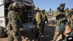 Syrian opposition fighters get off a truck as they enter the village of Anjara, western outskirts of Aleppo, Nov. 28, 2024, part of their major offensive on government-controlled areas in the country's northwestern.