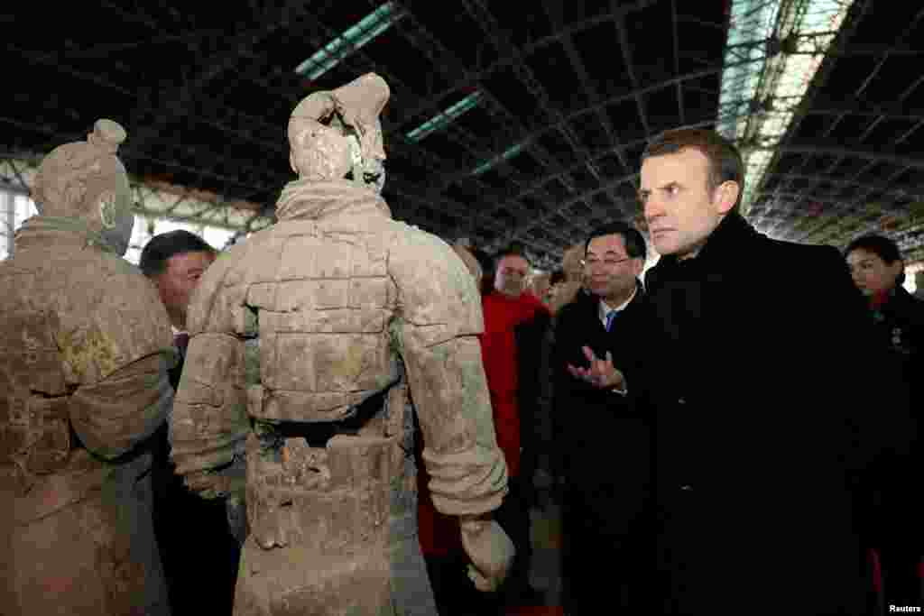 2018年1月8日,法国总统马克龙在中国陕西省西安市参观秦代兵马俑博物馆,近距离观察兵马俑。 马克龙携夫人布丽吉特开始对中国进行正式访问,在西安参观了兵马俑、有几百年历史的大雁塔和清真寺。