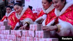 在中国杭州一个公园里，工作人员在一场有奖游戏中摆放百元钞票（2016年1月26日）