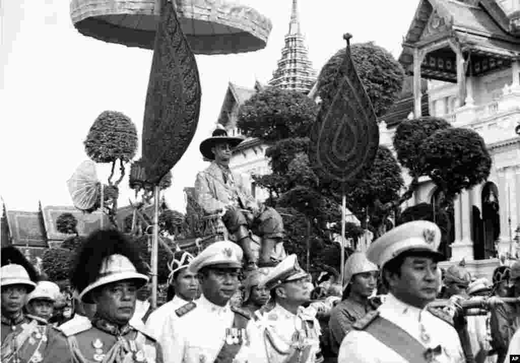 King Bhumibol Adulyadej is carried on the shoulders of Royal guards during a parade in Bangkok Dec. 7, 1963. The parade climaxed one week-long celebration of the King's 36th birthday.