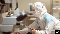 芯片技术人员在台湾联华电子公司(UMC)的“洁净室”测试设施检查硅片(资料照)