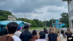 Sekelompok turis berdiri di dekat stasiun perbatasan di Panmunjom di Zona Demiliterisasi di Paju, Korea Selatan, Selasa, 18 Juli 2023. (AP/Sarah Jane Leslie)
