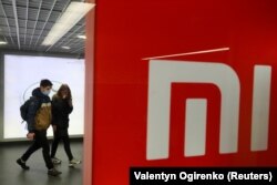 Orang-orang yang memakai masker pelindung wajah mengunjungi toko merek Xiaomi, di tengah wabah Covid-19 di Kyiv, Ukraina, 22 Oktober 2020. (Foto: REUTERS/Valentyn Ogirenko)