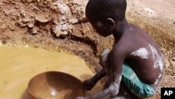Abou Keita, 5 ans, cherche de l'or dans la mine de Djikouloumba, près de la région de Kankan, en Guinée, 27 avril 2008. AP / Rukmini Callimachi