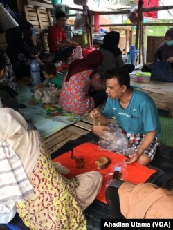 Para pengungsi etnis Hazara asal Afghanistan menikmati roti dan teh saat sarapan di dalam tenda darurat di Jakarta.
