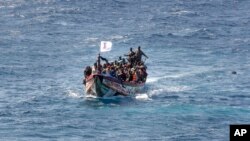 FILE - Migrants crowd a wooden boat as they sail to the port in La Restinga on the Canary island of El Hierro, Spain, on Aug. 18, 2024.