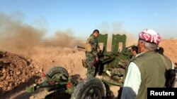 FILE - Kurdish Peshmerga forces fire a weapon during clashes with Islamic State militants in a village east of Mosul, Iraq, May 29, 2016. 