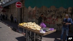 Palestinski prodavac sa tezgom ispred zatvorene prodavnice u Ramali na Zapadnoj obali. 2. maj, 2023. (Foto: AP/Nasser Nasser)