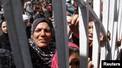 Palestinians gather to buy bread from a bakery which reopened after being shut for several months, in Gaza City, April 14, 2024