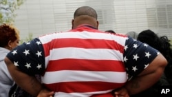 Seorang pria dengan kelebihan berat badan mengenakan baju dengan pola bendera AS ketika berkunjung ke World Trade Center, New York, pada 8 Mei 2014. Hampir 42 persen orang dewasa di AS mengalami obesitas. (Foto: AP/Mark Lennihan)