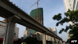 骑摩托车的人经过中国出资在河内修建的一处高架铁轨。（2014年9月12日资料照）