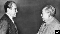 FILE - U.S. President Richard M. Nixon, left, shakes hands with Chinese communist party leader Chairman Mao Zedong during Nixon's groundbreaking trip to China, in Beijing, Feb 21, 1972.