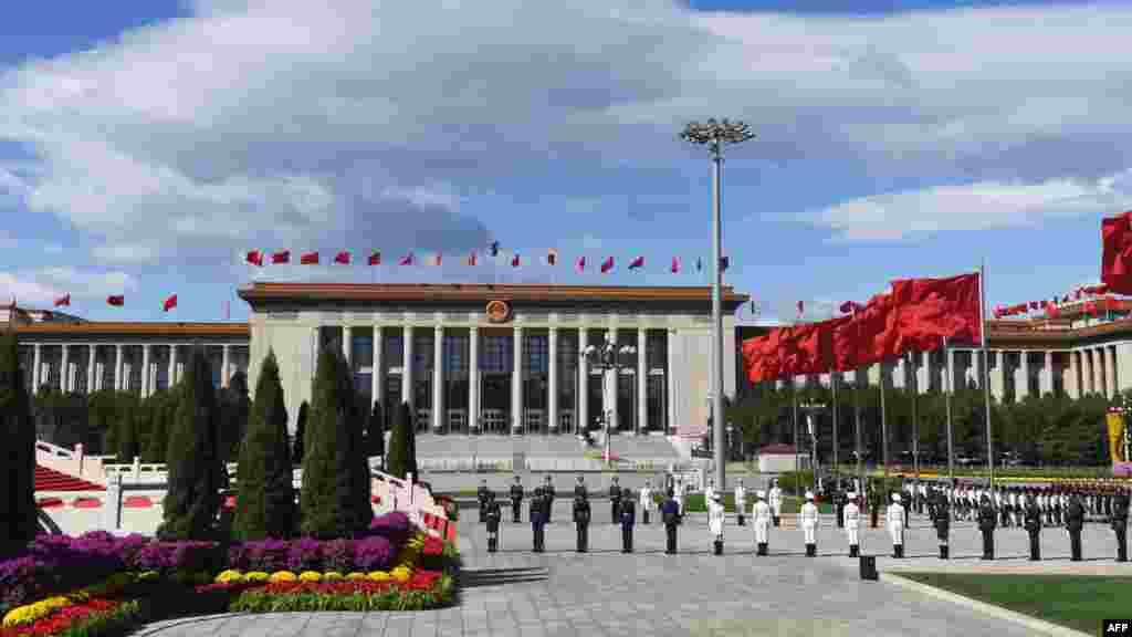 2018年9月30日,中国国庆节前夕,天安门广场举行仪式,军人列队肃立,蓝天白云,红旗飘扬,花团锦簇。这张照片和下一张,哪张能象征中国今后几年的前途?