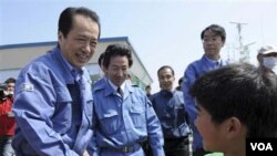 Perdana Menteri Jepang Naoto Kan (kiri) menjabat tangan seorang anak laki-laki di Ishinomaki, salah satu daerah yang terkena dampak parah bencana.