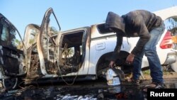 Seorang pria Palestina memeriksa di dekat kendaraan di mana 7 staf World Central Kitchen (WCK), termasuk orang asing, tewas dalam serangan udara Israel di Deir Al-Balah, Jalur Gaza (2/4). 