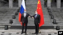 Menteri Luar Negeri Rusia Sergei Lavrov, kiri, bertemu dengan Menteri Luar Negeri China Wang Yi di Guilin di Daerah Otonomi Guangxi Zhuang, China selatan, Senin, 22 Maret 2021. (Foto: via AP)