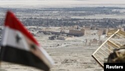 叙利亚国旗飘扬在叙利亚中部古城帕尔米拉的废墟附近（2016年4月1日）