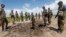 FILE - Somali soldiers stand at a Somali military base, near the site of an attack by al-Shabab, in Lower Juba, June 13, 2018. The base was the target of another al-Shabab assault Monday.