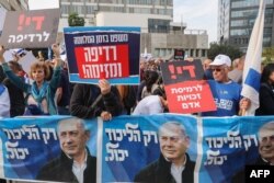 Demonstran membawa spanduk dan plakat mendukung Perdana Menteri Israel Benjamin Netanyahu selama persidangannya atas tuduhan korupsi di Tel Aviv, 10 Desember 2024. (Foto: Jack GUEZ/AFP)