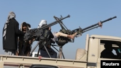 ក្រុម​ប្រដាប់អាវុធដែលគាំទ្រ​ក្រុម​ហ៊ូធី​ធ្វើដំណើរ​តាម​រថយន្ត​ដែល​មាន​បំពាក់​កាំភ្លើង​ នៅ​ក្បែរ​ក្រុង Sanaa ប្រទេសយេម៉ែន កាលពីថ្ងៃទី២៥ ខែមករា ឆ្នាំ២០២៤។ 