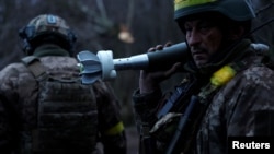 在乌克兰顿涅茨克州前线，在俄军持续进攻之际，乌军士兵准备发射迫击炮弹。(2022年12月31日)