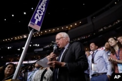 Former Democratic presidential candidate, Sen. Bernie Sanders, I-Vt., stands with the Vermont delegation and asks that Hillary Clinton become the unanimous choice for President of the United States during the second day of the Democratic National Convention.