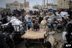 Seorang pria Palestina mengangkut karung bantuan kemanusiaan dengan kendaraan di luar pusat distribusi Badan Bantuan dan Pekerjaan PBB untuk Pengungsi Palestina (UNRWA), di Rafah di selatan Jalur Gaza pada 3 Maret 2024. (Foto: AFP)