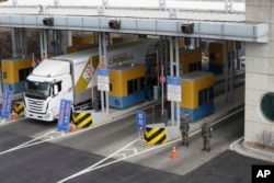 FILE - A South Korean truck heads to the North Korean city of Kaesong as South Korean Army soldiers stand guard at the customs, immigration and quarantine office near the border village of Panmunjom, in South Korea, Thursday, Feb. 11, 2016.