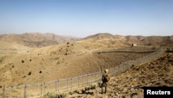 FILE - A soldier stands guard along a border fence on the border with Afghanistan in North Waziristan, Pakistan, Oct. 18, 2017. Militant attacks against Pakistani security outposts Friday reportedly resulted in the deaths of at least six soldiers and injuries to 14 others. 