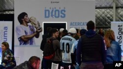 Fans antre merekam pesan untuk bintang sepak bola Diego Maradona dalam presentasi sebuah pesawat yang didedikasikan untuk mendiang pemain sepak bola, di sebuah pangkalan militer di Morón, pinggiran Buenos Aires, Argentina, Sabtu, 23 Juli 2022. (AP/Gustavo Garello)