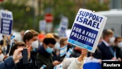 Seorang perempuan memegang plakat pro-Israel saat demonstrasi umendukung Palestina, di Frankfurt, Jerman 15 Mei 2021. (Foto: REUTERS/Kai Pfaffenbach)