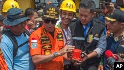 Predstavnici nacionalne Agencije za potragu i spasavanje pokazuju pronađenu crnu kutiju