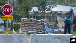 Pakistan police officers man a checkpoint outside the house of former President Pervez Musharraf, where he has been held under house arrest, in Islamabad, Oct 10, 2013.
