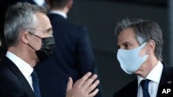 Menteri Luar Negeri AS Antony Blinken, kanan, dan Sekretaris Jenderal NATO Jens Stoltenberg mengenakan masker pelindung saat mereka bersiap untuk berdiri bersama para menteri luar negeri NATO selama pertemuan para menteri luar negeri NATO. (Foto: AP)