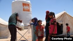 Displaced Iraqis from Fallujah fill their jerrycans with water supplied by the Norwegian Refugee Council at Amariyat Al Fallujah displacement camp, June 11, 2016. Photo: Karl Schembri/NRC