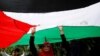 Demonstran memegang bendera Palestina dalam demonstrasi di depan Kedutaan Besar Amerika di Jakarta, untuk mengecam keputusan AS mengakui Yerusalem sebagai Ibu Kota Israel, 8 Desember 2017.