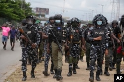 Police officers patrol during a protest against the economic hardship on the street in Lagos, Nigeria, Aug 2, 2024.