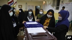 Election officials open a ballot box for the presidential elections at a polling station in Tehran, Iran, early on June 19, 2021. Iranians voted Friday in a presidential election dominated by Supreme Leader Ayatollah Ali Khamenei's hard-line protege.