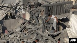 Warga Palestina berjalan di atas puing-puing bangunan yang hancur akibat pemboman Israel di kamp pengungsi Nuseirat, di Jalur Gaza tengah pada 30 Oktober 2023. (Foto: AFP)