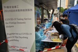Para pekerja migran mendaftar tes COVID-19 di distrik Central, Hong Kong, Sabtu, 1 Mei 2021. (Foto: Peter Parks/AFP)