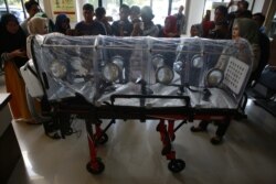 Seorang petugas kesehatan menerangkan kepada para wartawan tandu untuk membawa pasien yang terinfeksi virus corona dari bandara ke rumah sakit, di Lampung, 28 Januari 2020. (Foto: AFP)