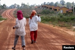 រូប​ឯកសារ៖ ស្ត្រី​ពីរ​នាក់​ដើរលើ​ផ្លូវ​មួយក្នុងឧទ្យានជាតិ​បុទុមសាគរ​ខេត្ត​កោះកុង ដែល​ត្រូវ​បាន​សាងសង់​សម្រាប់​អ្នក​ដែល​ត្រូវ​បានជម្លៀសចេញ​ពី​ដី​ដែល​ត្រូវ​បាន​លក់។ រូបថត ​កាលពីថ្ងៃ​ទី​២០ ខែ​កុម្ភៈ ឆ្នាំ​២០១២។