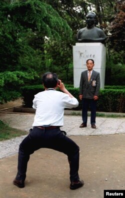 北京大学校友在中国最著名的教育家之一，北京大学前校长蔡元培的塑像前拍摄纪念照。