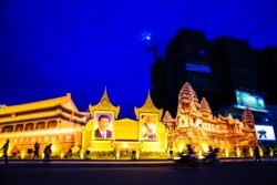 រូបឯកសារ៖ ប្រជាពលរដ្ឋ​ដើរកាត់​ការតុបតែង​លំអ​រ​អម​ស្វាគមន៍​លោកប្រធានា​ធិបតី​ចិន​ Xi Jinping (ឆ្វេង)និង​រូប​ថត​ព្រះ​មហាក្សត្រ​ខ្មែរ​ព្រះបរមនាថ​នរោត្តម​សីហមុនី ​ក្នុងទស្សន​កិច្ច​ផ្លូវ​រដ្ឋ​នៅ​កម្ពុជារបស់​លោកប្រធានាធិបតី​ចិន​មក​កម្ពុជា ថ្ងៃទី១៣ ខែតុលា ឆ្នាំ២០១៦។