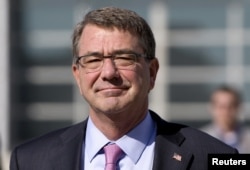 FILE - U.S. Defense Secretary Ash Carter walks on the tarmac before boarding his plane at Queen Alia Airport in Amman, Jordan, July 24, 2015.