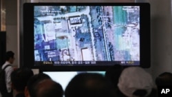 FILE - South Koreans watch a television broadcasting a satellite image of the nuclear facility in North Korea, at the Seoul Railway Station in Seoul, South Korea, Oct. 8, 2013.